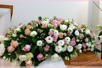 Delicate pink and peach casket spray