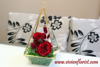 Red eternal roses in gold geometric vase