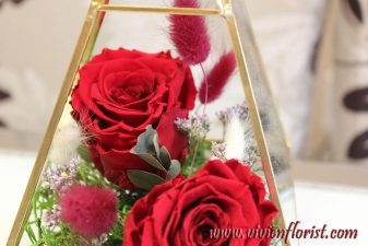 Red eternal roses in gold geometric vase