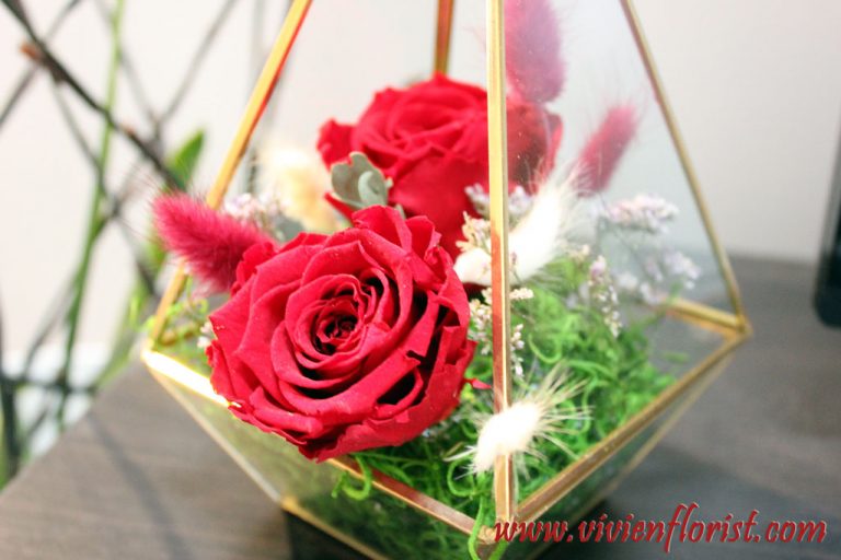 Red eternal roses in gold geometric vase