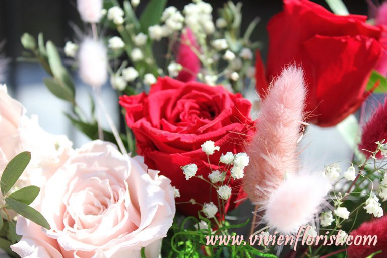 Red and pink eternal roses in clay vase