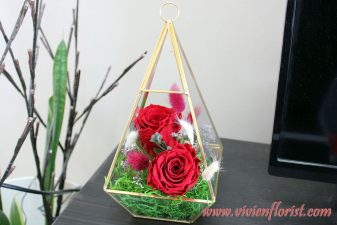 Red eternal roses in gold geometric vase